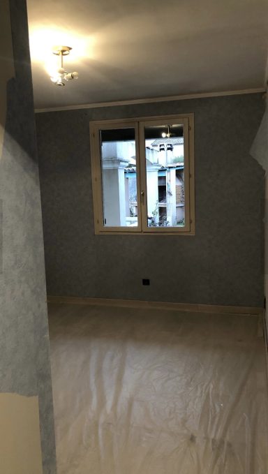 travaux de rénovation en cours : dépose d'un papier peint usé et préparation des murs